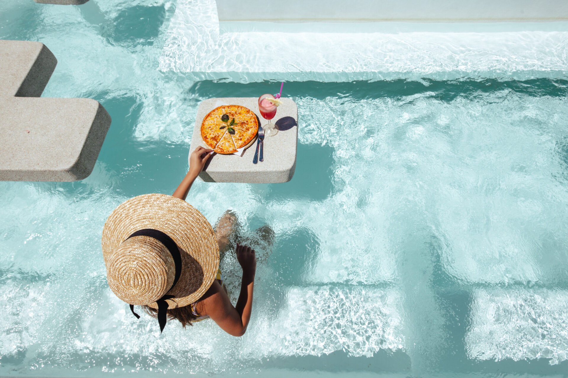 Woman sitting in pool with floating tray